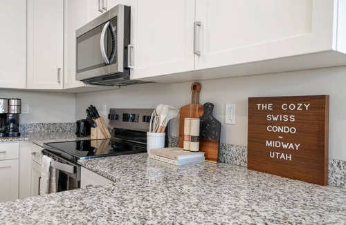 Midway Condo | Cozy Swiss Condo - King Bed, Sleeps 6, Free Blanket