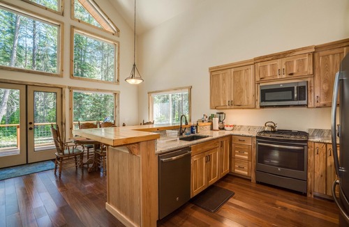 Plain House | Riverfront cabin with a hot tub & fireplace.